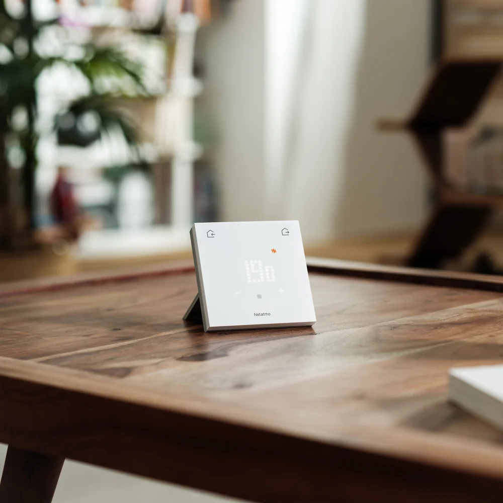 The ORIGINAL Thermostat on its stand, on a wooden coffee table
